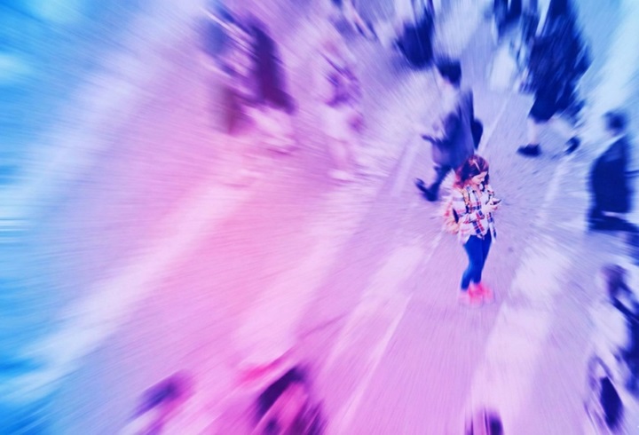 Gente por la calle y mujer con el móvil