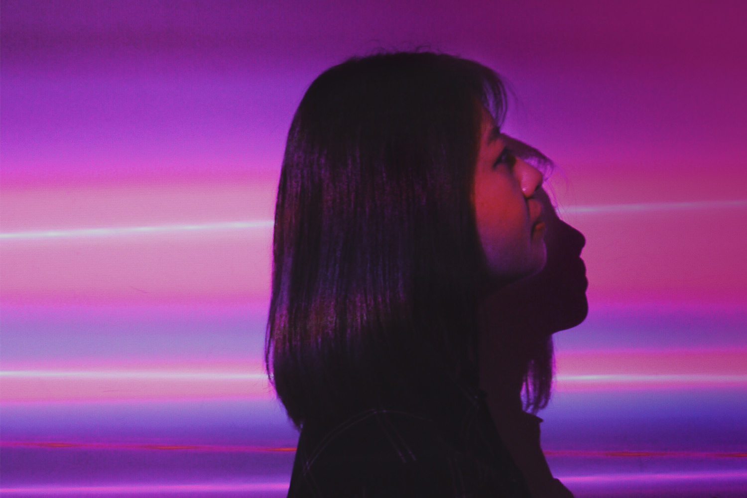 silueta de mujer en fondo morado y rosa