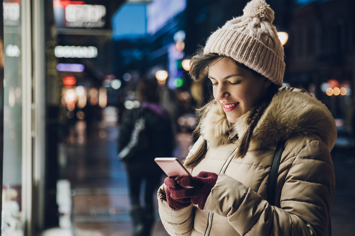 mujer escribiendo en su móvil en invierno